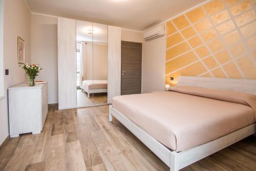 a bedroom with a bed and a mirror at Casa Baratta - La terrazza sulle Langhe in Neive