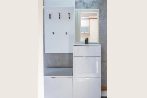 a bathroom with white cabinets and a mirror at Montesan Luxury Apartments Sveti Stefan in Sveti Stefan