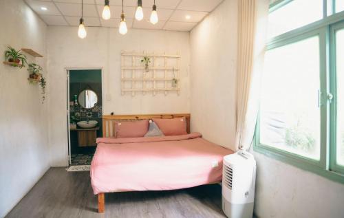a bedroom with a pink bed and a window at Dreamers Garden Farmstay in Hoat