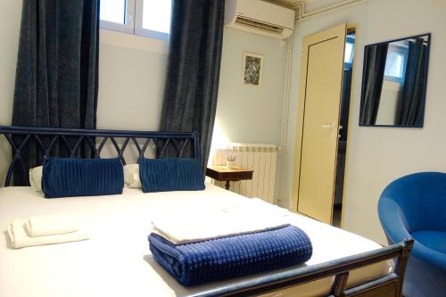 a bedroom with a bed and two blue chairs at Villa Loop Beograd in Belgrade