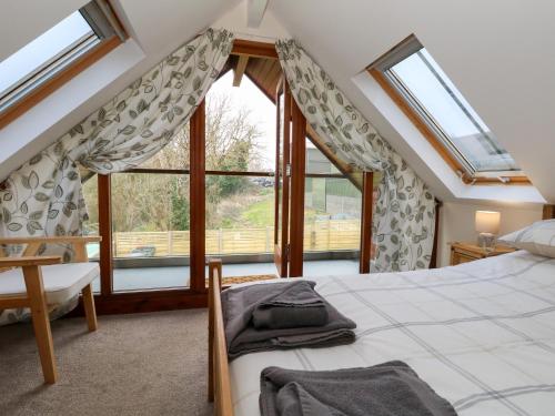 Un dormitorio con una cama y una ventana grande. en Little Dairy House, en Swanage
