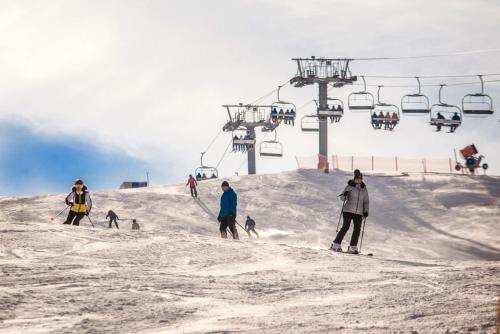 a group of people skiing on a ski lift at Apartmán Danadrin Family Evergreen Tále in Tale