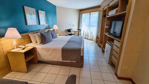 a hotel room with a bed and a tv at Reymar Hotel Maceió in Maceió