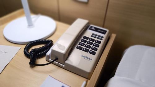 a phone sitting on top of a desk at Reymar Hotel Maceió in Maceió