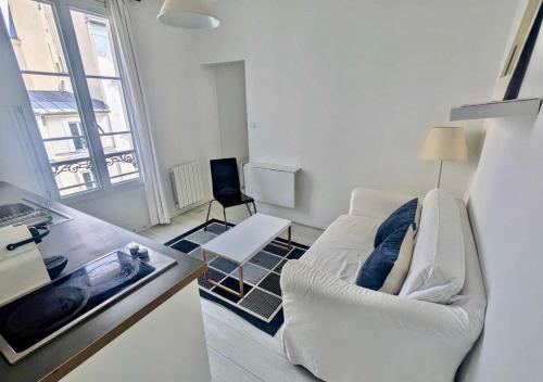 un salon avec un canapé blanc et une table dans l'établissement Moderne appart central 2 personnes, à Paris
