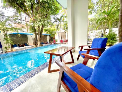 a patio with a table and chairs next to a swimming pool at SKY VILLA - BKK Phnom Penh - Rooms & Apartments - FREE LAUNDRY in Phnom Penh