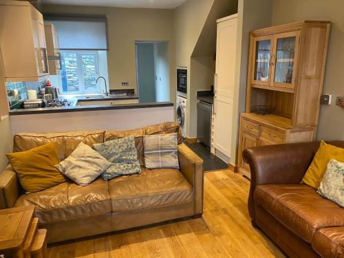 ein Wohnzimmer mit Sofa und eine Küche in der Unterkunft Riverside Cottage with secure bike storage in Staveley