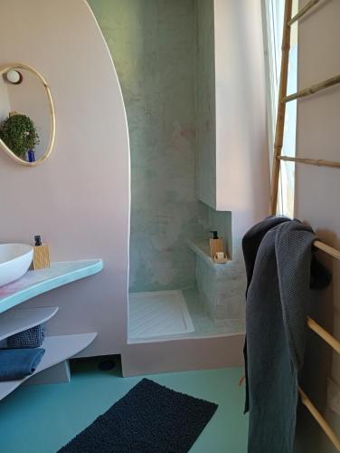 une salle de bain avec un lavabo et un miroir dans l'établissement Chez Olive et Garance, à Couret