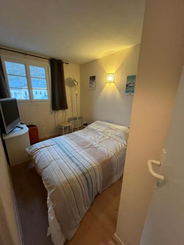 une petite chambre avec un lit et une télévision dans l'établissement Charmant duplex en plein centre de Cauterets de 4 à 6 couchages et 2 chambres dont une sous-toit, à Cauterets