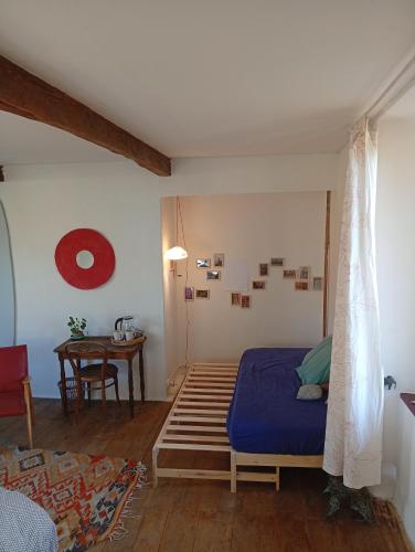 - une chambre avec un lit bleu et une table dans l'établissement Chez Olive et Garance, à Couret