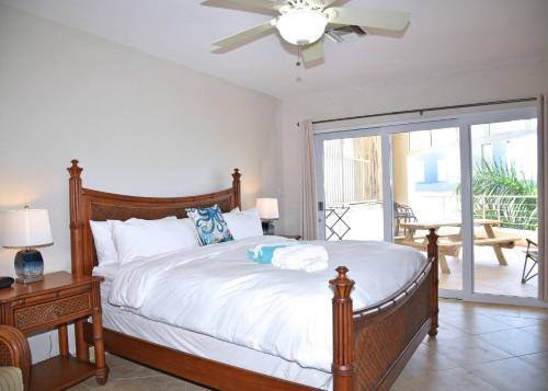 a bedroom with a bed and a sliding glass door at Oceanfront Paradise: Penthouse with Peloton in Lowlands