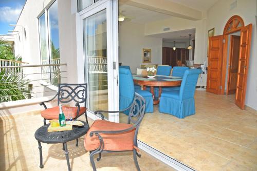 a patio with blue chairs and a table at Oceanfront Paradise: Penthouse with Peloton in Lowlands