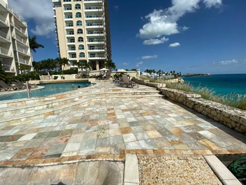 a resort with a swimming pool next to the ocean at Oceanfront Paradise: Penthouse with Peloton in Lowlands