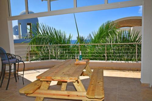a wooden picnic table on a balcony with a view at Oceanfront Paradise: Penthouse with Peloton in Lowlands