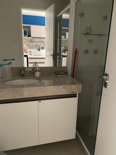 a white bathroom with a sink and a shower at Hotel em CABO FRIO Cond Royale - Av N S Assunção 239, bairro Passagem - un 229 in Cabo Frio