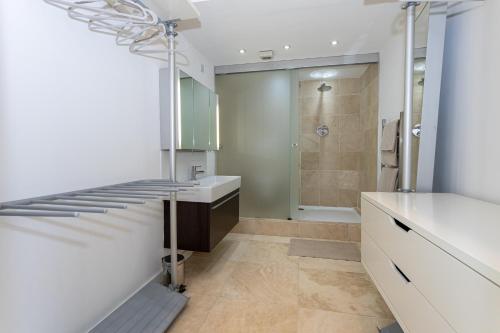a bathroom with a walk in shower and a sink at Luxury Penthouse with Private Roof Terrace in Manchester