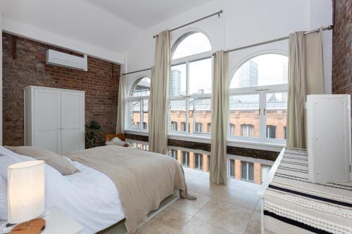 a bedroom with a bed and a large window at Luxury Penthouse with Private Roof Terrace in Manchester