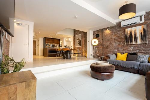 a living room with a couch and a brick wall at Luxury Penthouse with Private Roof Terrace in Manchester