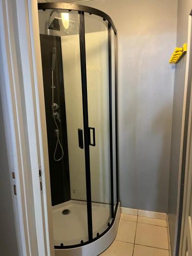 une douche avec une porte vitrée dans une salle de bain dans l'établissement Appartement au calme en rdc, à Banyuls-sur-Mer