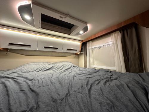 a bedroom with a bed and a tv on the wall at Элитный автодом для семьи in Tbilisi City