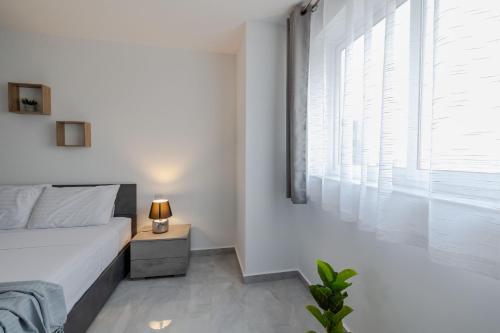 a white bedroom with a bed and a window at Stunning 2BR Apartment in Sliema - APT 23 in Sliema