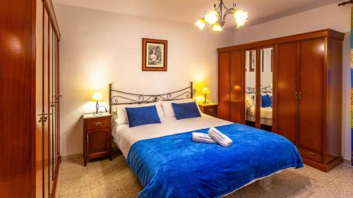 a bedroom with a large bed with blue sheets at La Fuente Romana Priego de Córdoba by Ruralidays in Priego de Córdoba