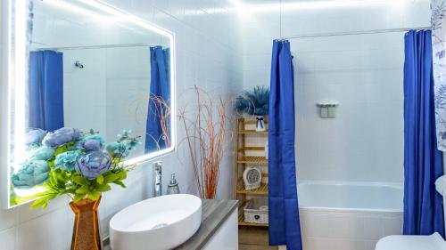 a bathroom with blue curtains and a sink and a shower at La Fuente Romana Priego de Córdoba by Ruralidays in Priego de Córdoba