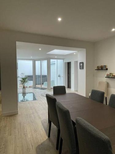 une salle à manger avec une table et des chaises en bois dans l'établissement Belle Maison Loft patio jacuzzi clim Tours, à Tours