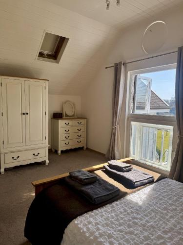 a bedroom with a bed and a large window at Medway Hot Tub Lodge in South Cerney