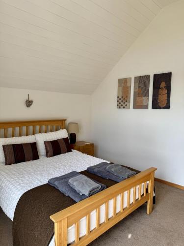 a bedroom with a wooden bed in a room at Medway Hot Tub Lodge in South Cerney