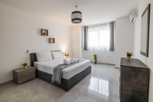 a bedroom with a large bed in a white room at Stunning 2BR Apartment in Sliema - APT 23 in Sliema