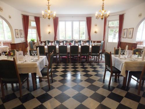 a dining room with tables and chairs and chandeliers at Hotel Restaurant Grünwalderhof in Innsbruck