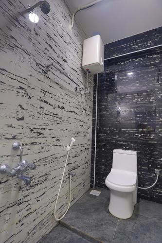 a bathroom with a white toilet and a shower at AN Hotel chennai airport in Chennai
