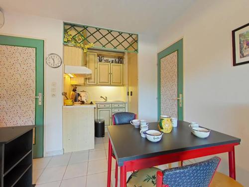 - une cuisine avec une table et des bols dans l'établissement Appartement 2 pièces avec terrasse et piscine, La Londe-les-Maures - FR-1-826-9, à La Londe-les-Maures