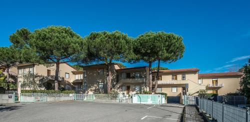a parking lot in front of a building with trees at Caletta Apartments in Castiglioncello