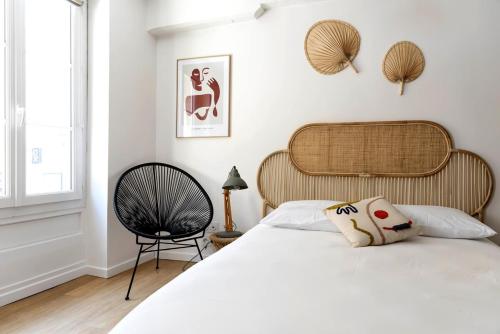 une chambre avec un lit blanc et une chaise dans l'établissement Charmant studio en plein coeur du centre-ville, à Caen
