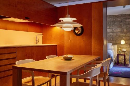 a kitchen and dining room with a wooden table and chairs at Hotel Neri – Relais & Chateaux in Barcelona