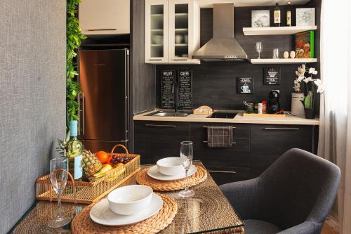 a kitchen with a table with two plates and glasses at City Center Apartments with Parking in Plovdiv