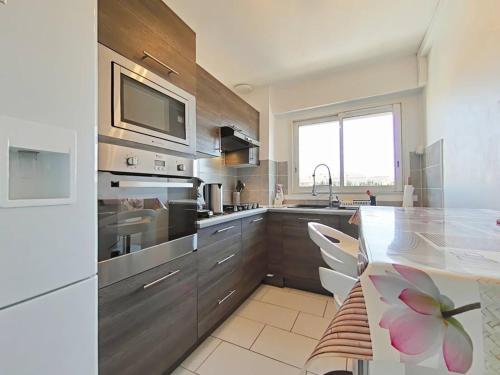 une cuisine avec des appareils en acier inoxydable et un comptoir dans l'établissement Appartement T2 climatisé avec balcon et parking à La Londe - FR-1-826-1, à La Londe-les-Maures