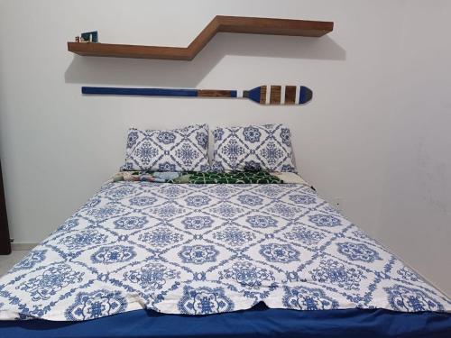 a bed with a blue and white quilt and pillows at Apto frente pro mar 3 pedra in Itapoa