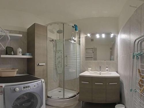 une salle de bain avec douche et lavabo et une machine à laver dans l'établissement Appartement T2 climatisé avec balcon et parking à La Londe - FR-1-826-1, à La Londe-les-Maures