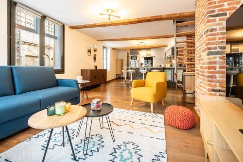 un salon avec un canapé bleu et une table dans l'établissement Duplex Rue Royale, rooftop, balnéo spa, à Lille