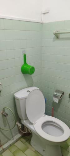 a bathroom with a white toilet in a green wall at Trellis Homes in Colombo