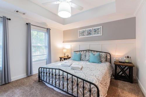 a bedroom with a bed with blue pillows and a window at Pearl of the Promenade in Bluffton
