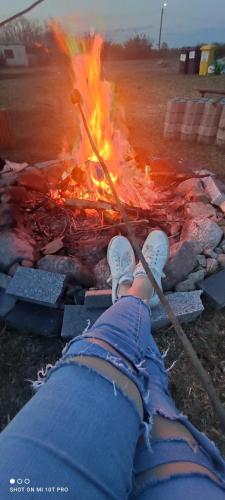 a person is sitting in front of a fire at Żurawisko - Domki wśród natury in Jesiona