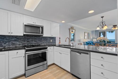 a kitchen with white cabinets and stainless steel appliances at Romar Tower Unit 1A in Orange Beach