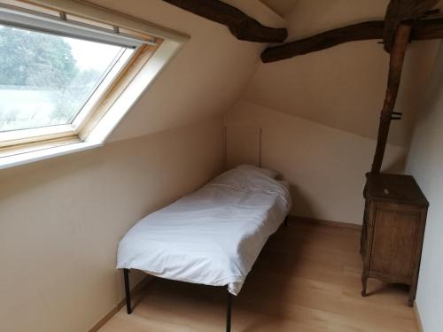 Un dormitorio pequeño con una cama y una ventana. en Duplex, en Ronse