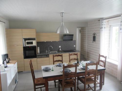 a kitchen with a table and chairs in a room at Maison de vacances avec jardin clos à 300m de la mer in Pouldreuzic