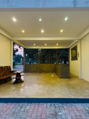 a large empty room with a table and a bench at Ceyloni Sigiriya in Dambulla
