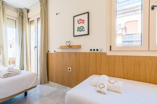 ein Hotelzimmer mit zwei Betten und einem Fenster in der Unterkunft Al Sur Home in Sevilla